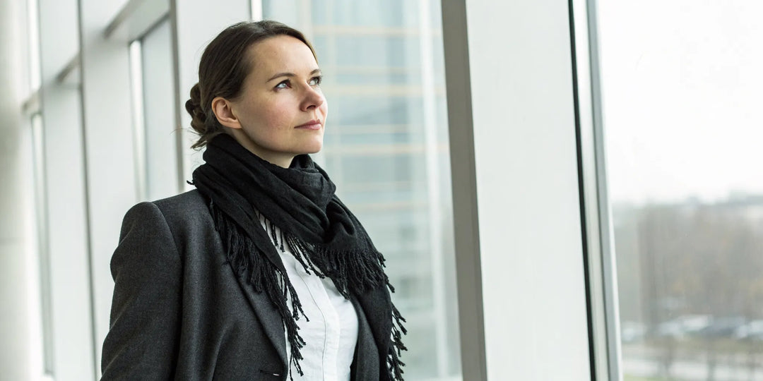 Grosse écharpe noire pour femme, portée pour un look d'hiver chic et confortable.