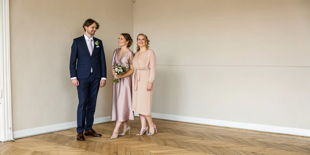 Invités élégants en costume et robes pastel, parfaits pour s'habiller pour un mariage.